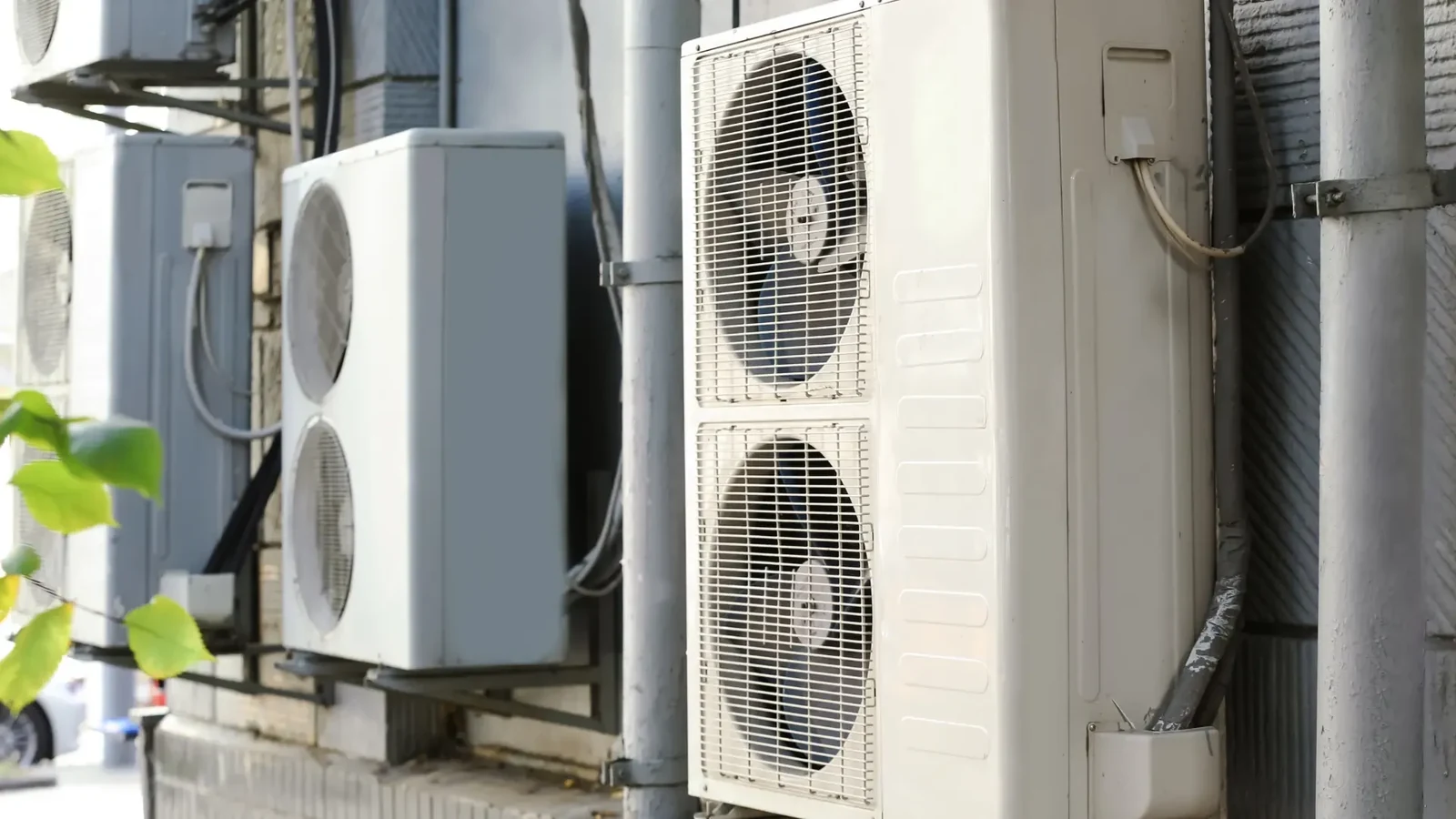 Several wall-mounted outdoor condenser units with visible pipework